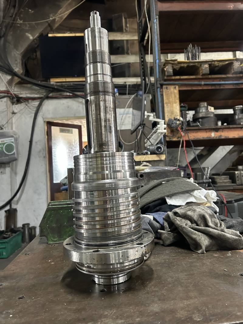 Machine spindle assembly standing on a workshop bench